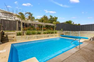 Family w Large Pool & Game Garage Wlk to Beach في كاوز: حمام سباحة في الفناء الخلفي للمنزل