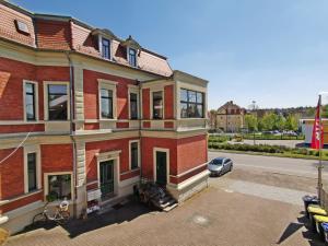a large brick building with a car parked in front of it at Musashi Apartment 3 in Weimar