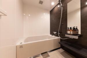 uma casa de banho com uma banheira e um lavatório em KAjette em Takayama