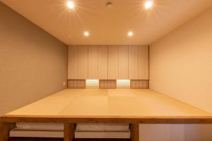 高山市にあるKAjetteのテーブルと白いキャビネット付きの広い客室です。