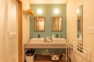 a bathroom with two sinks and two mirrors at KAjette - Takayama Apartment Hotel in Takayama