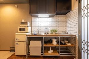 a kitchen with a counter with a sink and a refrigerator at KAjette - Takayama Apartment Hotel in Takayama