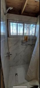 baño con ducha y suelo de mármol grande. en LA VECINDAD en Dique Luján