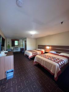 um quarto de hotel com duas camas e uma cozinha em American Inn em Branford