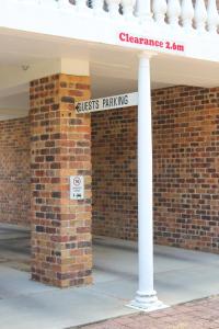 a street sign in front of a brick building at Aston Motel Yamba in Yamba