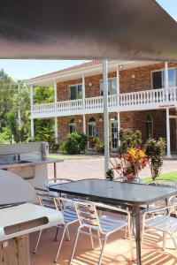 a patio with a table and chairs and a building at Aston Motel Yamba in Yamba