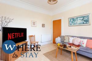 un salon avec un canapé et une télévision dans l'établissement Bright 2bed apartment in Galashiels City Centre, à Galashiels