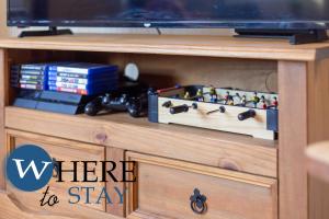 un centre de divertissement en bois avec une télévision et des jouets dessus dans l'établissement Bright 2bed apartment in Galashiels City Centre, à Galashiels