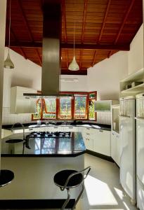 een keuken met een fornuis en een aantal stoelen. bij Casa da Montanha in Mairiporã
