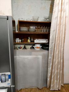 uma prateleira com pratos ao lado de um frigorífico em Дили Дом em Dilijan