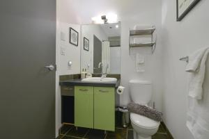 a bathroom with a white toilet and a sink at Harbourview Executive Condo in Victoria