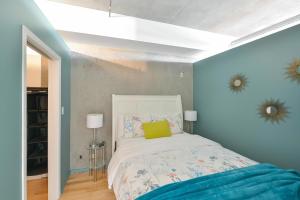 Schlafzimmer mit einem Bett mit blauer Wand in der Unterkunft Harbourview Executive Condo in Victoria