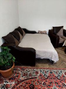 um quarto com uma cama, um sofá e um tapete em Дили Дом em Dilijan