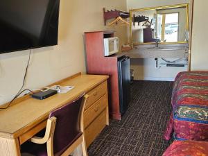 a small hotel room with a desk and a microwave at Cle Elum Travelers Inn in Cle Elum
