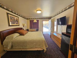 Habitación de hotel con cama y TV en Cle Elum Travelers Inn, en Cle Elum