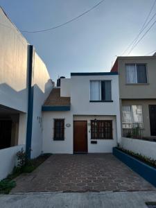 uma casa branca com uma entrada de tijolos em Casa Mediterraneo em Ensenada