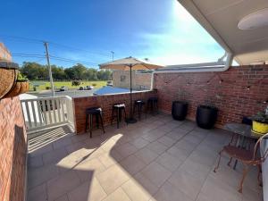 a patio with tables and chairs and an umbrella at Downtown Narrabri in Narrabri