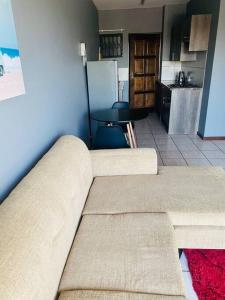 a living room with a couch and a kitchen at 2 bedroom apartment close to OR Tambo in Kempton Park