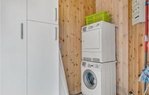- un lave-linge et un sèche-linge à côté d'un mur en bois dans l'établissement Gorgeous Home In Ringkbing With Kitchen, à Søndervig