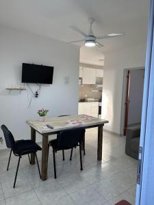 a table in a living room with two chairs and a television at DON SIMON Apart 8 -departamento nuevo in Esperanza