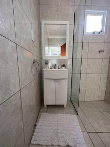 a bathroom with a sink and a shower with a mirror at DON SIMON Apart 8 -departamento nuevo in Esperanza