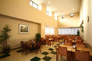 a restaurant with tables and chairs in a room at APA Hotel Mie Kameyama in Kameyama