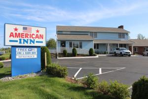 a sign for an american inn in a parking lot at American Inn in Branford