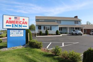 um sinal para uma estalagem americana num parque de estacionamento em American Inn em Branford