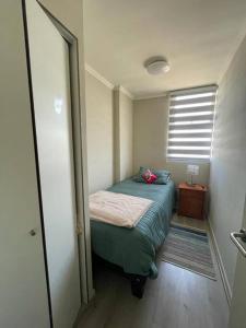 Habitación pequeña con cama y ventana en Departamento en La Cruz Entre La Calera y Quillota, en La Cruz
