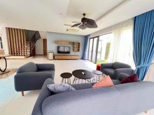 a living room with a blue couch and a table at Hoang Hai Villas 7 Phu Quoc - 4 Bedrooms - Shared Swimming Pool in Phu Quoc