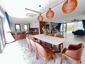 富國的住宿－Hoang Hai Villas 7 Phu Quoc - 4 Bedrooms - Shared Swimming Pool，用餐室以及带桌椅的起居室。