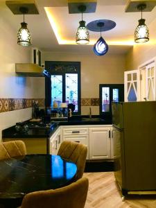 cocina con mesa y nevera negra en Casa murcia, en Chefchaouen