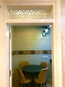 a dining room table with yellow chairs around it at Casa murcia in Chefchaouene