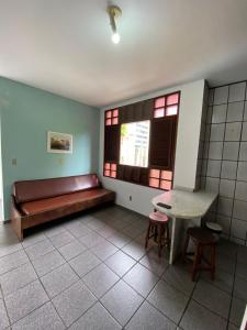 Habitación con banco, mesa y ventanas en Apartamento Mobiliado Mozart, en Natal