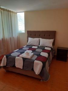 a bedroom with a large bed with towels on it at Hostal Ayllu in Urubamba