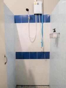 y baño con ducha y azulejos azules y blancos. en Leisure Hostel, en Krabi