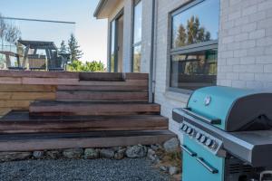 a bbq grill sitting outside of a house at Two Fantails in Lake Tekapo