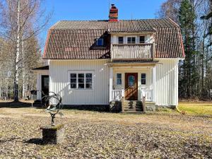 a small white house with a porch and a balcony at 4 person holiday home in HÖJE-By Traum in Höje