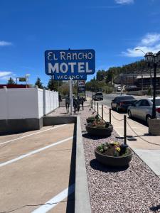 una señal para un motel en un estacionamiento en El Rancho Motel, en Williams