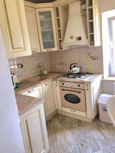 a kitchen with white cabinets and a stove top oven at Dream House in Bălţi +35 photos