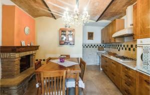 cocina con mesa de madera y chimenea en Lovely Home In Mazzolla With Wifi en Mazzolla