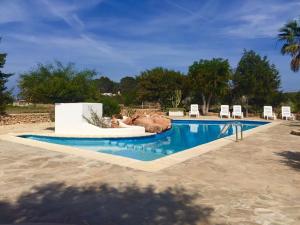 a swimming pool with chairs and a lazy river at Apartamentos Vista Vedrá in La Savina