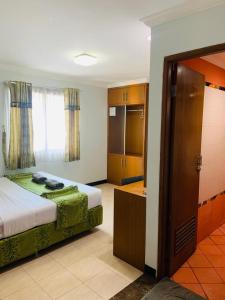 Habitación de hotel con cama y baño en Karsa Utama Hotel, en Yakarta