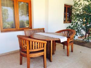 a wooden table with two chairs and a window at Apartamentos Vista Vedrá in La Savina