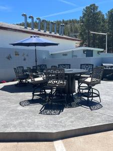 a table and chairs with an umbrella on a patio at El Rancho Motel in Williams
