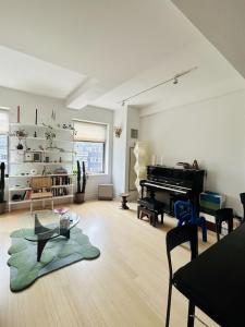 a living room with a table and a piano at Sunny & Cozy Apt with a Piano in a hot Brooklyn Neighborhood in Brooklyn