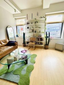 a living room with a couch and a glass table at Sunny & Cozy Apt with a Piano in a hot Brooklyn Neighborhood in Brooklyn