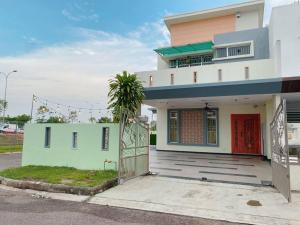 uma casa branca com uma porta vermelha e um portão em A05 SkyBlue Desa Tebrau em Johor Bahru
