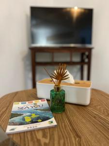 ein Buch und eine Pflanze in einer Vase auf einem Tisch in der Unterkunft Ti bwa Lodge in Capesterre-Belle-Eau