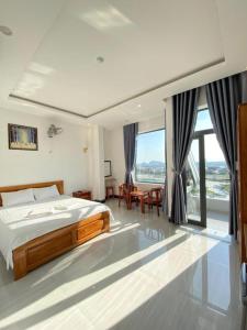 - une chambre avec un lit, une table et des chaises dans l'établissement Queen Hotel, à Tuy Hoa